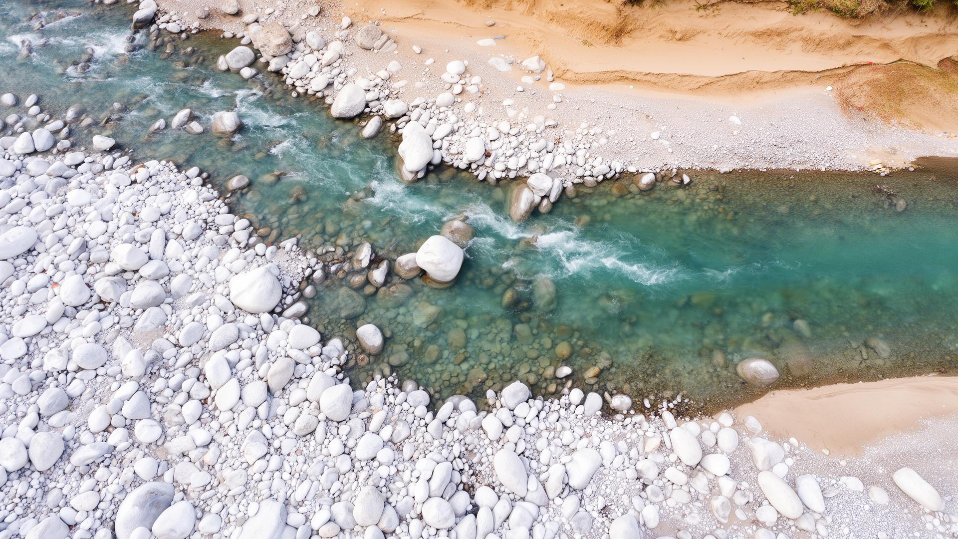 The Ganga river flowing over white pebbles near Rishikesh